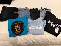 All seven clothing items laid out: jeans, sweatshirts, hoodie, jacket