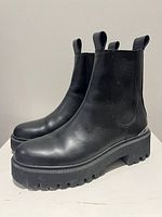 Side view of both boots showing leather upper, platform sole and general condition