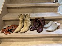 All four pairs on stair: sandals, boots, heels, mules