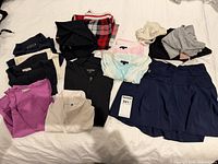 Overview of all 13 clothing items laid out on bed