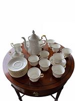 Full set arranged on table: coffee pot, cups, saucers