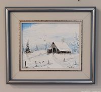 Framed winter landscape painting on wall