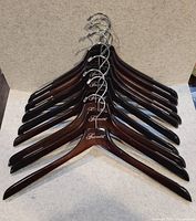 Stacked view of all ten Fairmont wood hangers showing colour and hooks