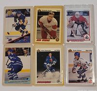 Front view of six sleeved hockey cards