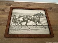 Front view of framed black and white horse racing photograph