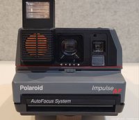 Front view showing Polaroid Impulse AF branding, flash, sonar sensor and lens