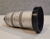 Side view of silver Sony zoom lens showing hood and zoom/focus rings