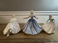 Front view of three Royal Doulton figurines