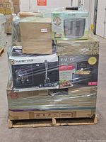 Front view of pallet showing Rowenta vacuum box, Instant air fryer oven box, range hood box and additional air fryer box