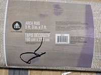 Label showing Hometrends branding and rug size 5 ft 3 in × 7 ft