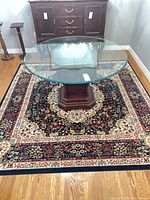 Full view of square oriental-style rug under glass table