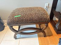 Full view of bench showing leopard upholstery and wood frame