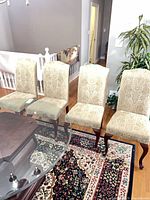 Four upholstered side chairs around glass table