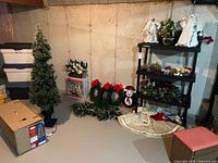 Overview of tree, wreaths, garland, angels, floral decor on shelving, tree skirt