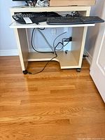 Front view showing keyboard tray, casters and open shelf