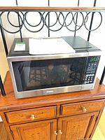 Front view of Danby microwave on wooden cabinet