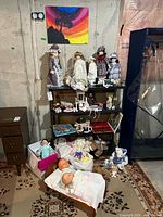 overview showing porcelain dolls on shelf, plush toys and books