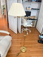 Full view of brass-tone floor lamp with pleated shade