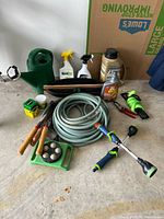 Group shot of all garden supplies including hoses, watering can, tools and chemicals