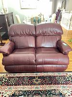 Front view of burgundy leather La-Z-Boy reclining loveseat