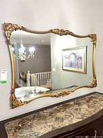 Front view of rectangular mirror showing full gilt frame and reflection