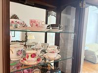 Cabinet shelf with seven assorted teacup and saucer sets
