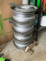 Stack of four steel rims, side profile showing rust and size