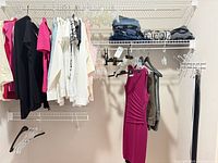 Overview of hanging tops, dresses, folded jeans and scarves
