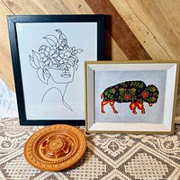 Group shot of all three items: buffalo spirit print, floral woman line art print, carved wood plate