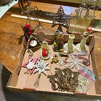 Overview of entire lot inside box showing candleholders, wire stars, metal reindeer, figurines and assorted ornaments