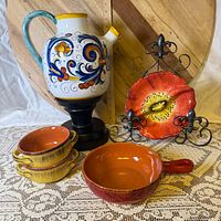 Group view of pitcher, two yellow bowls, red pan, poppy plate