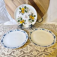 Three ceramic platters displayed on stands