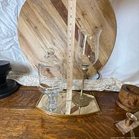 Group of items including mirror tray, apothecary jar, hurricane glass, wood bowl, background board