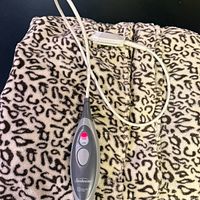 Folded leopard-print Sunbeam heated throw showing controller attached