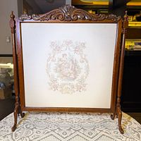 Full view of firescreen showing carved crest, legs and tapestry