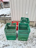seven plastic milk crates stacked outdoors on snow