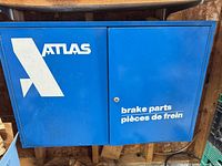 Front view showing Atlas logo and bilingual text on blue metal cabinet
