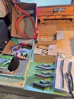 Overall view of lot showing packaged and loose brushes, deer whistles and hose