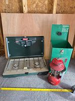 Stove open beside lantern and case