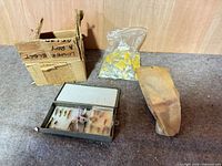 Group shot showing tackle box with flies, plastic bag of jigs, paper bundle, and cardboard box