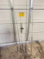 Five fishing rods leaning against garage door