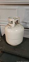 Front view of white steel propane cylinder with protective collar