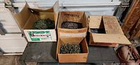 Four cardboard boxes with loose screws and nails