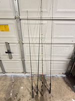 Four fishing rods leaning against garage door