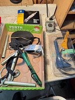 Overall lot showing woven strap, metal handles, green puller hook, boxed rope hoist and blister pack puller