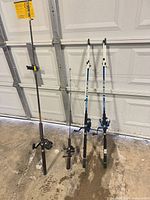 All four fishing rods and reels standing against garage door