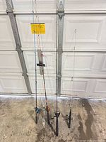 Four fishing rods leaning against garage door