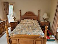 Four-poster queen bed frame with one nightstand visible