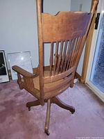 Rear view of wooden swivel chair showing spindle back and swivel base