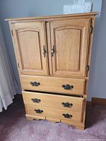 Front view of oak armoire showing double doors and two drawers